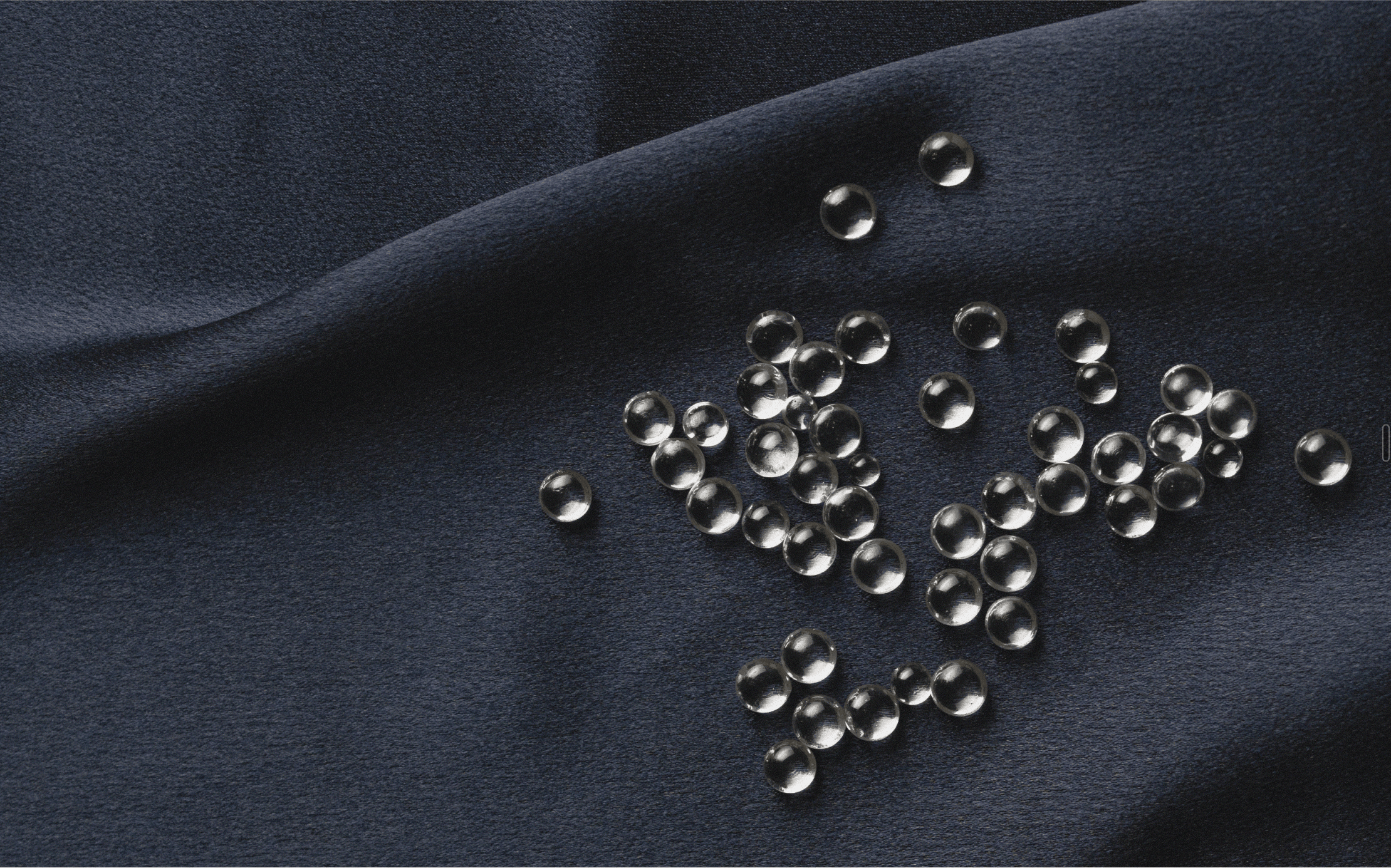 Glass beads scattered across dark navy fabric