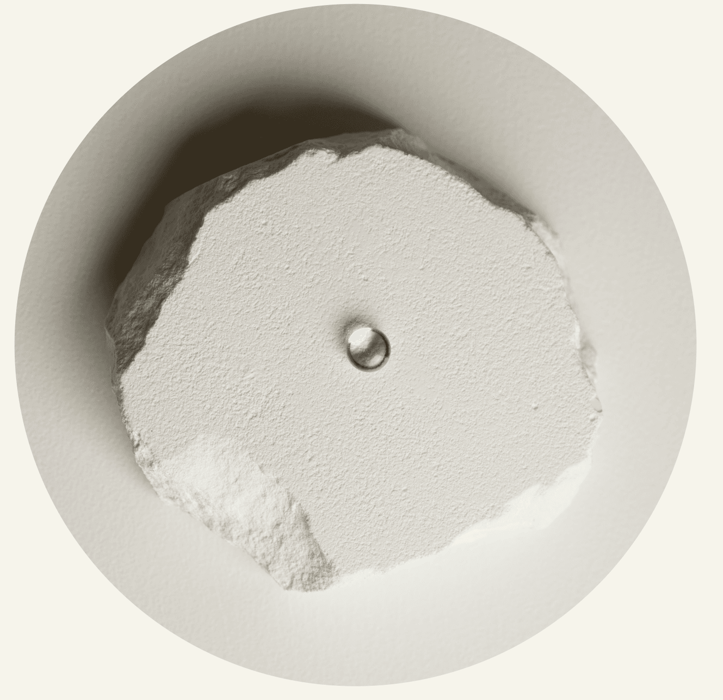 A single Selah Stone resting on a raw stone disc